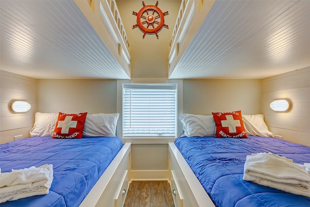 bedroom featuring wooden walls and hardwood / wood-style floors