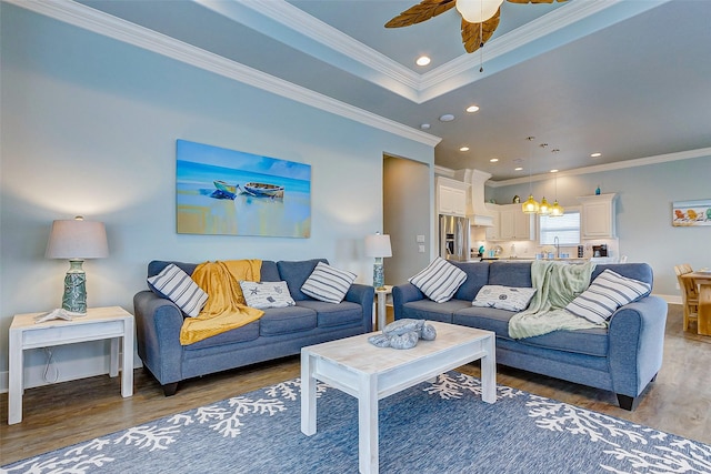 living room featuring crown molding, sink, dark wood-type flooring, and ceiling fan with notable chandelier