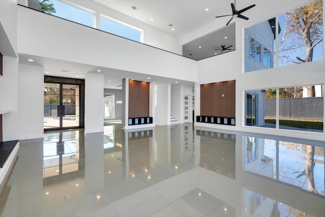 interior space with a towering ceiling and ceiling fan