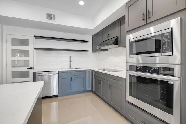 kitchen with sink, decorative backsplash, light tile patterned flooring, and appliances with stainless steel finishes