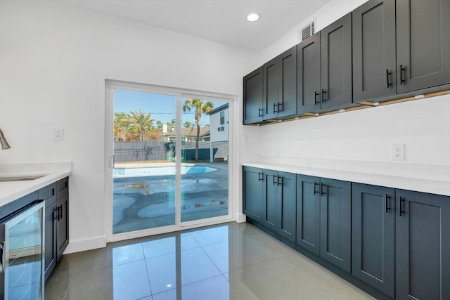 kitchen with wine cooler, light tile patterned flooring, and sink