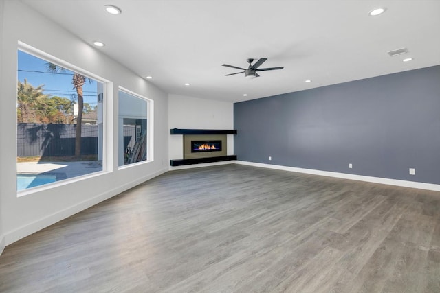 unfurnished living room with ceiling fan and wood-type flooring