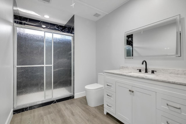 bathroom featuring vanity, toilet, a shower with shower door, and hardwood / wood-style floors