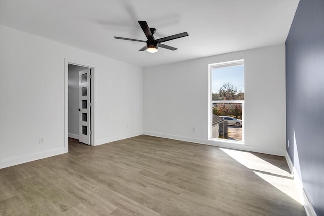 empty room featuring hardwood / wood-style flooring and ceiling fan