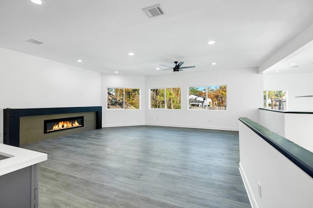 unfurnished living room featuring ceiling fan and dark hardwood / wood-style floors