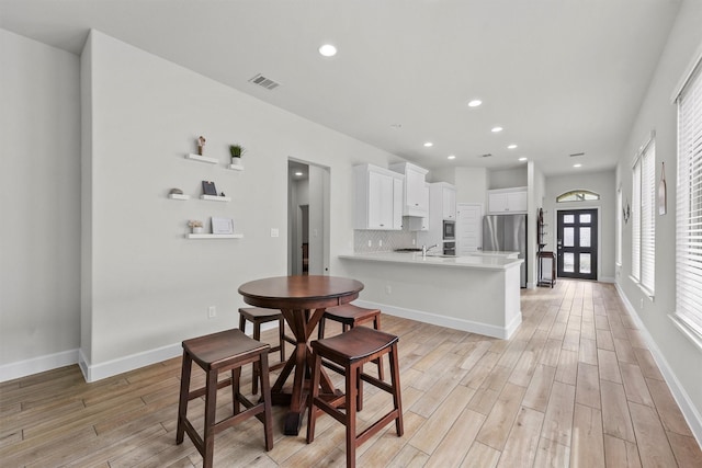 dining area with sink and light wood-type flooring