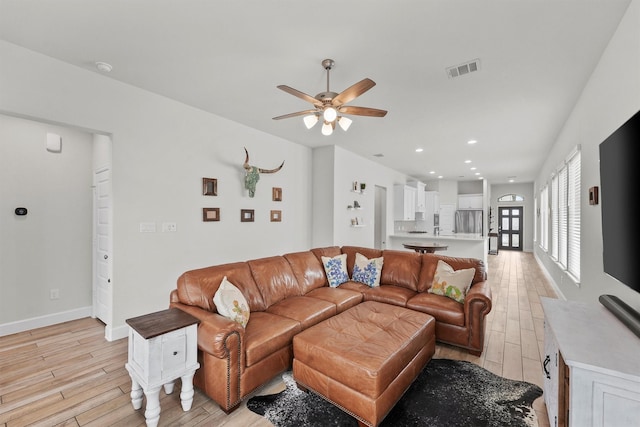 living room featuring ceiling fan and light hardwood / wood-style flooring