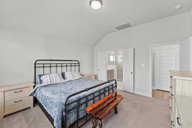 carpeted bedroom featuring ensuite bathroom and vaulted ceiling