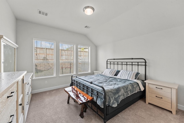 bedroom with vaulted ceiling and light colored carpet