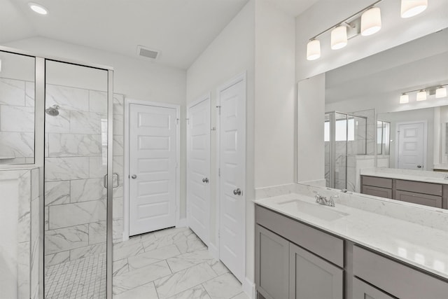 bathroom featuring vanity, lofted ceiling, and a shower with shower door