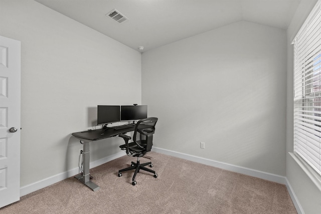 carpeted home office featuring vaulted ceiling