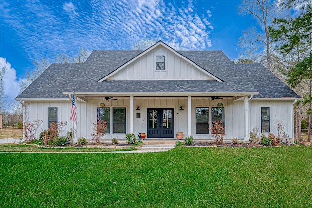 modern inspired farmhouse with a shingled roof, board and batten siding, a front lawn, and a ceiling fan