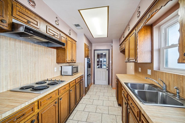 kitchen featuring sink, double oven, tasteful backsplash, white electric cooktop, and light tile patterned flooring