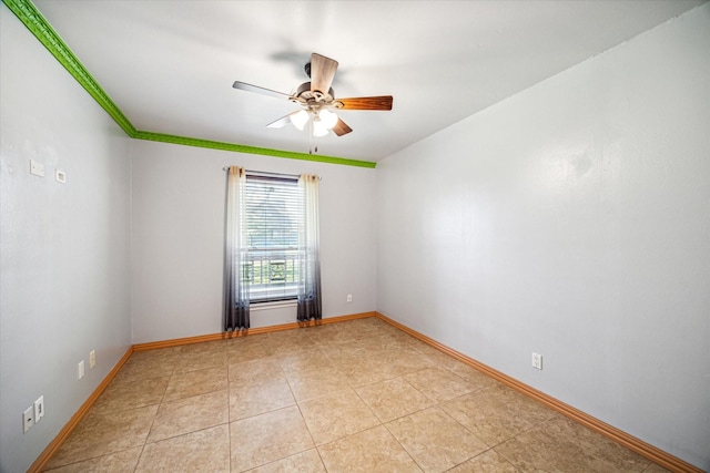 empty room with ceiling fan and light tile patterned floors