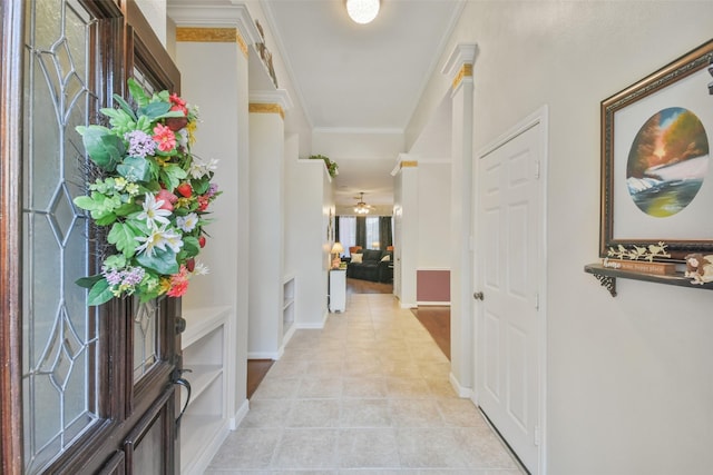 hall with ornamental molding and light tile patterned flooring