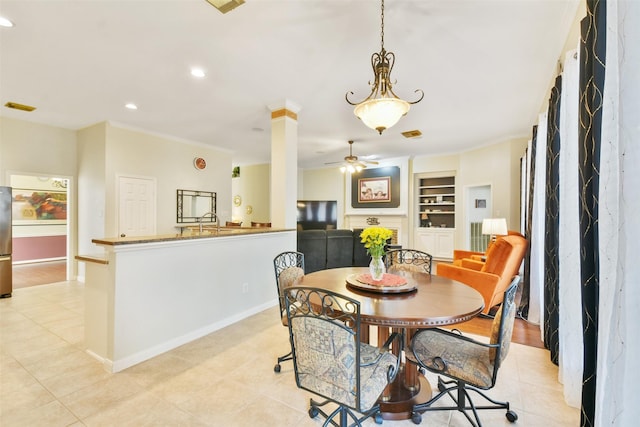 dining room featuring decorative columns, ornamental molding, ceiling fan, and built in shelves