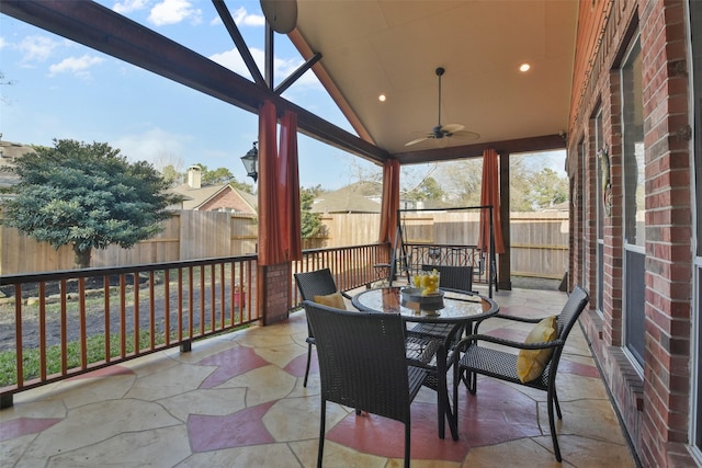 sunroom with ceiling fan and lofted ceiling