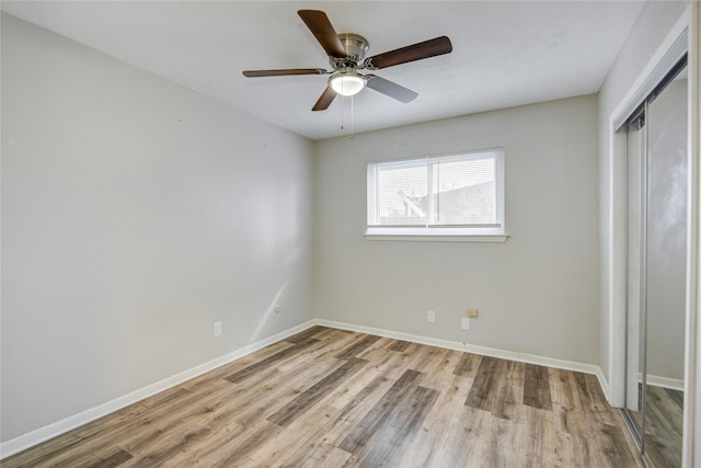 unfurnished bedroom featuring ceiling fan, a closet, and light wood-type flooring