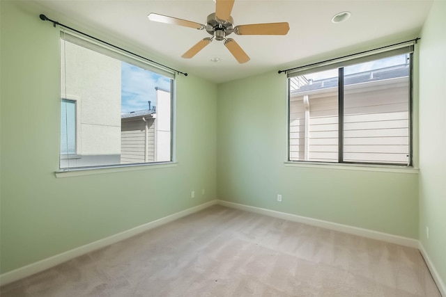 unfurnished room featuring light colored carpet and ceiling fan