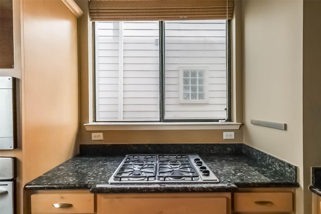 kitchen featuring stainless steel gas stovetop and dark stone counters