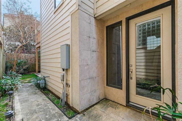 view of exterior entry with a patio area