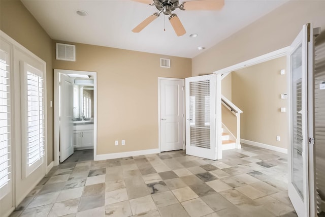 unfurnished bedroom featuring ceiling fan, ensuite bathroom, and sink