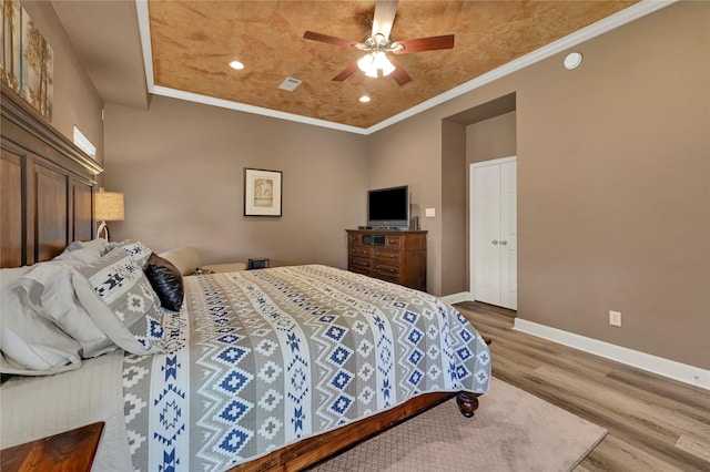 bedroom featuring hardwood / wood-style flooring, ornamental molding, and ceiling fan