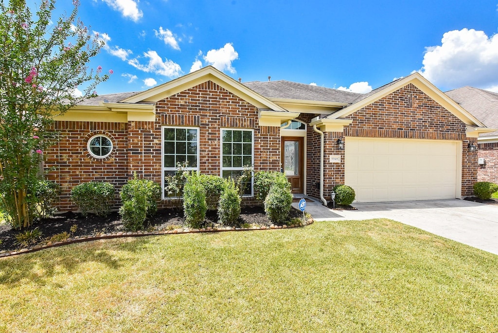 view of front of home with a garage and a front lawn