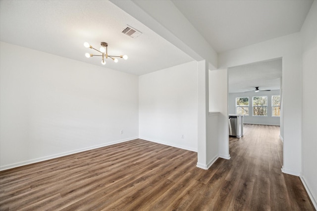 unfurnished room featuring an inviting chandelier and dark hardwood / wood-style floors