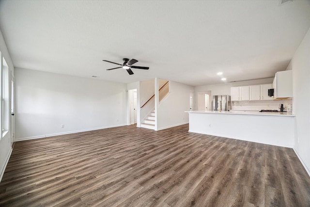 unfurnished living room with ceiling fan and dark hardwood / wood-style floors