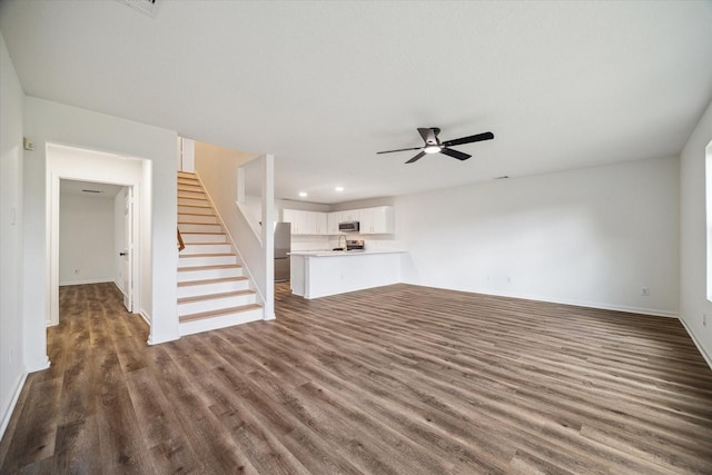 unfurnished living room featuring dark hardwood / wood-style flooring and ceiling fan