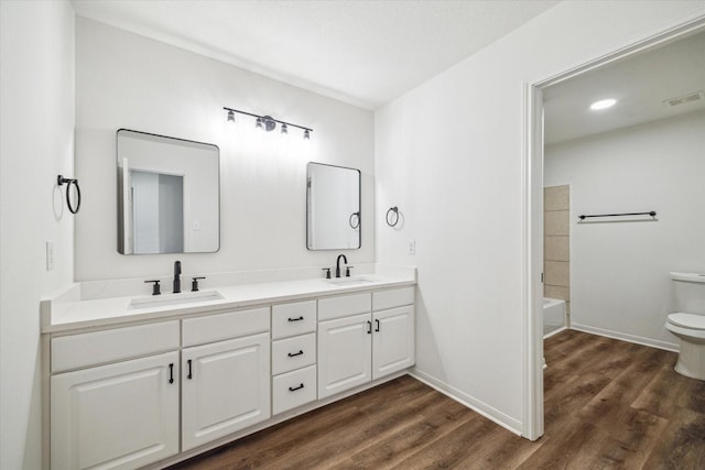 full bathroom with vanity, hardwood / wood-style floors, shower / bathtub combination, and toilet