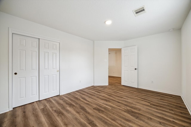 unfurnished bedroom featuring a closet and dark hardwood / wood-style floors