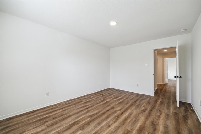 spare room featuring dark wood-type flooring