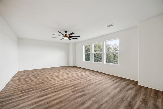 empty room featuring dark hardwood / wood-style flooring and ceiling fan