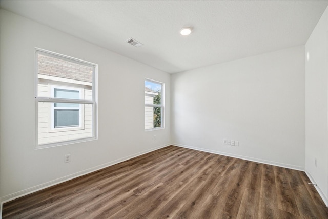 unfurnished room with dark wood-type flooring