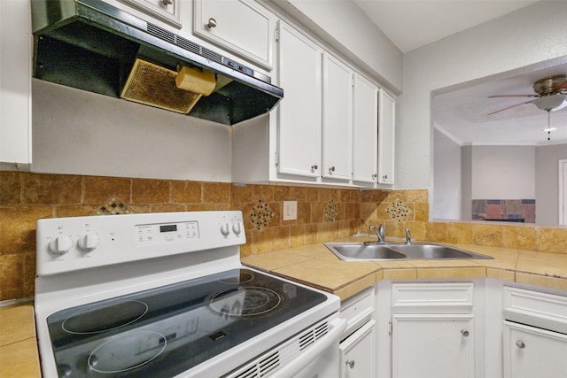 kitchen featuring white cabinets, sink, tile countertops, and electric range