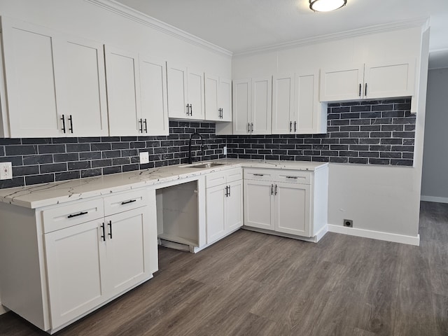 kitchen featuring sink, dark hardwood / wood-style floors, tasteful backsplash, ornamental molding, and white cabinets