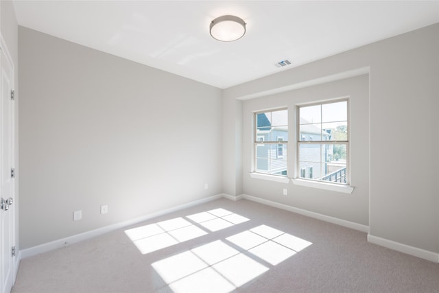 unfurnished room featuring light carpet