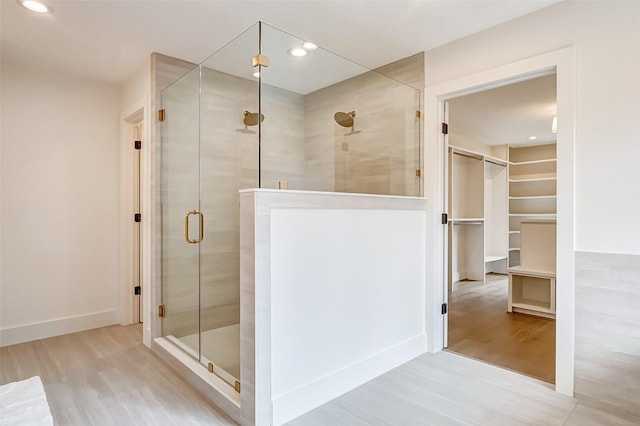 bathroom with wood-type flooring and an enclosed shower