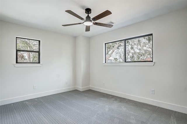 carpeted spare room featuring plenty of natural light and ceiling fan