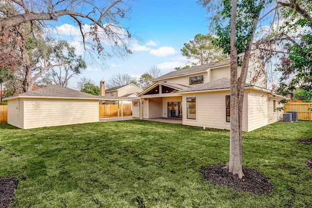 rear view of property featuring a yard, central AC, and a patio area