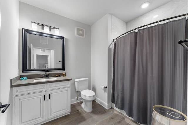 bathroom featuring vanity, wood-type flooring, a shower with shower curtain, and toilet