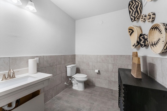 bathroom featuring tile walls, sink, tile patterned flooring, and toilet