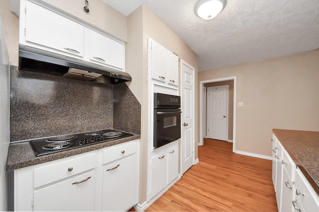 kitchen with a textured ceiling, white cabinets, light hardwood / wood-style floors, and black appliances