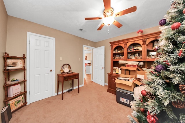 carpeted home office with ceiling fan