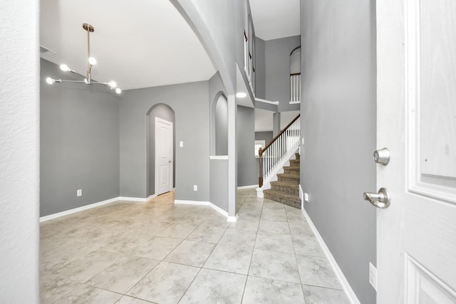 foyer featuring light tile patterned floors and a chandelier