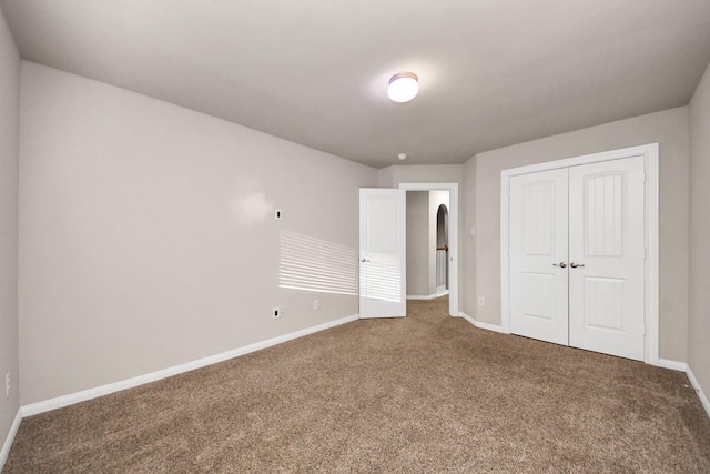 unfurnished bedroom featuring carpet flooring and a closet