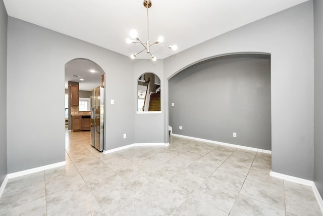 tiled empty room featuring a notable chandelier