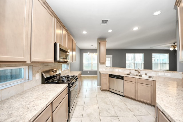 kitchen featuring sink, tasteful backsplash, light brown cabinets, appliances with stainless steel finishes, and pendant lighting